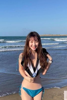 Gadis cantik mengambil gambar tamat pengajian dalam angin sejuk di pantai